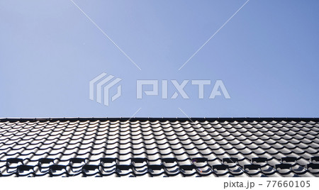 Brown corrugated metal profile roof installed on a modern house. The roof of corrugated sheet. Roofing of metal profile wavy shape. Modern roof made of metal. Metal roofing. Brown corrugated metal profile roof installed on a modern house. The roof of corrugated sheet. Roofing of metal profile wavy shape. Modern roof made of metal. Metal roofing. 77660105