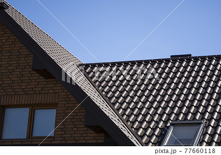 Brown corrugated metal profile roof installed on a modern house. The roof of corrugated sheet. Roofing of metal profile wavy shape. Modern roof made of metal. Metal roofing. Brown corrugated metal profile roof installed on a modern house. The roof of corrugated sheet. Roofing of metal profile wavy shape. Modern roof made of metal. Metal roofing. 77660118