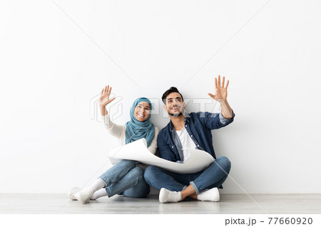 Loving muslim couple thinking about design in new house 77660920