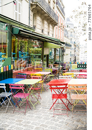 フランスパリの街並み　カフェの店先に並べられたカラフルな椅子とテーブル 77665764