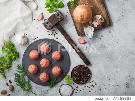 Fresh beef meatballs on stone board with pepper, salt and garlic on light background with dill 77665882