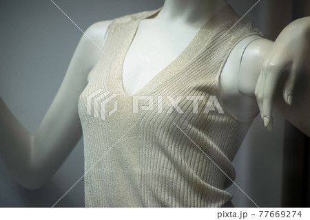 Closeup of beige tee-shirt on mannequin without bra in a fashion store showroom 77669274