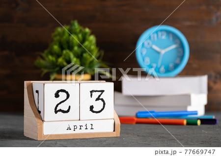 April 23rd. April 23 wooden cube calendar with blur objects on background. 77669747