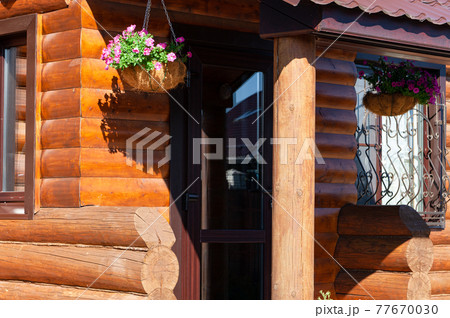 Fragment of log wooden house with decorated entrance. Country lifestyle. 77670030