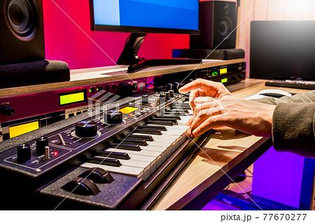 male musician hands playing keyboard for recording midi tracks in home studio. music production concept male musician hands playing keyboard for recording midi tracks in home studio. music production concept 77670277