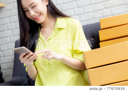 Young asian woman is entrepreneur check order from smartphone with customer while purchase online. 77670930