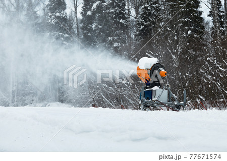 Snow cannon spraying out a fresh dusting of snow on the ski slopes. Snow cannon spraying out a fresh dusting of snow on the ski slopes. 77671574