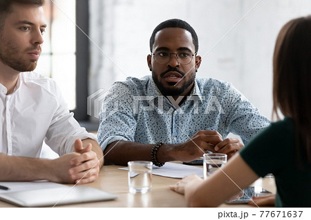Focused African American HR manager talking to job candidate Focused African American HR manager talking to job candidate 77671637