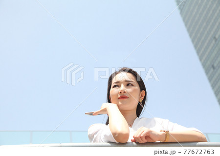 上目線の可愛い女性青空バック 上目線の可愛い女性青空バック 77672763