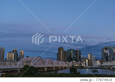 淀川河川敷から見た大阪駅周辺高層ビル群 都市景観　夕景 77674913