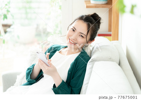 スマホを見る若い女性 スマホを見る若い女性 77675001