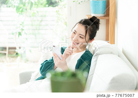 スマホを見る若い女性 77675007