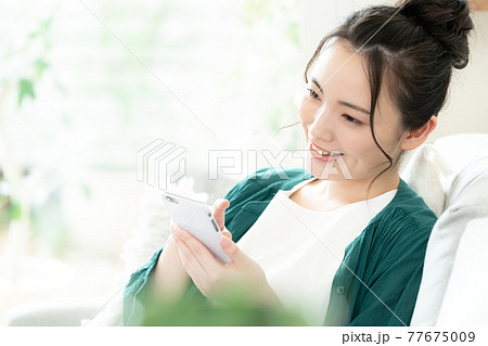 スマホを見る若い女性 スマホを見る若い女性 77675009