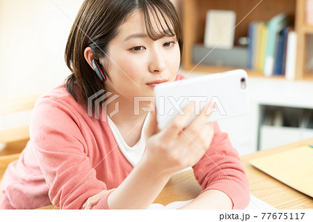 スマートフォンを見る若い女性 77675117