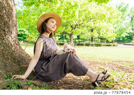 小型犬と散歩する若い女性 木陰でひと休み 柏の葉公園 小型犬と散歩する若い女性 木陰でひと休み 柏の葉公園 77678454