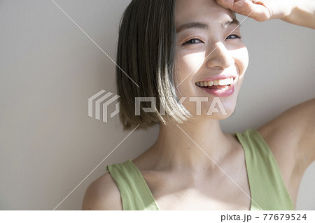 日差しを眩しいと感じる女性のポートレートの写真素材 [77679524] - PIXTA