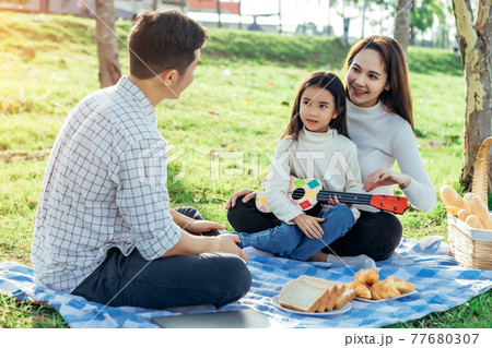 Happy asian family in the garden They play ukulele, singing, take pictures by film camera, eat together and have fun. Happy asian family in the garden They play ukulele, singing, take pictures by film camera, eat together and have fun. 77680307