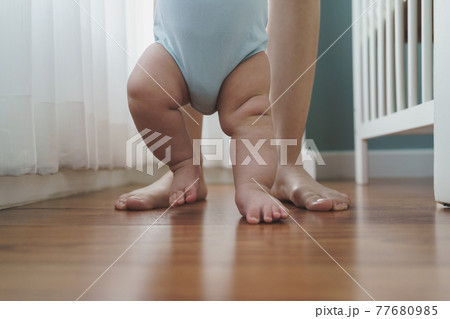 Asian Mother holding her little baby hands learning to walk Asian Mother holding her little baby hands learning to walk 77680985