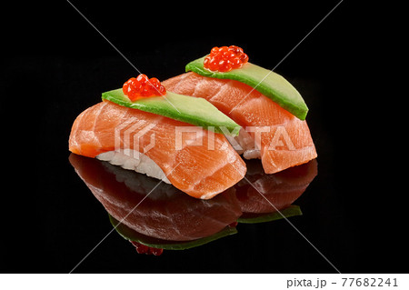 Two nigiri sushi with salmon, avocado, caviar on black background Two nigiri sushi with salmon, avocado, caviar on black background 77682241
