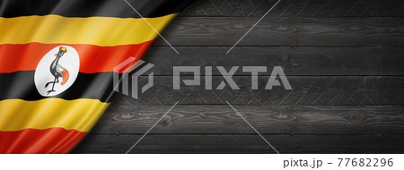Uganda flag on black wood wall banner Uganda flag on black wood wall banner 77682296