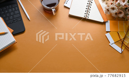 Designer workplace with, notebook, coffee cup, color swatch and copy space on yellow leather. Designer workplace with, notebook, coffee cup, color swatch and copy space on yellow leather. 77682915