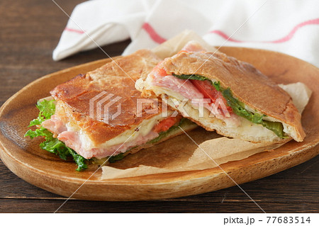 木皿に盛られたイタリア風パニーニのホットサンドイッチ 77683514