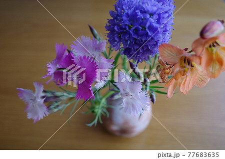 萩焼の花瓶に生けられたカラフルな3種類の春の花の写真素材