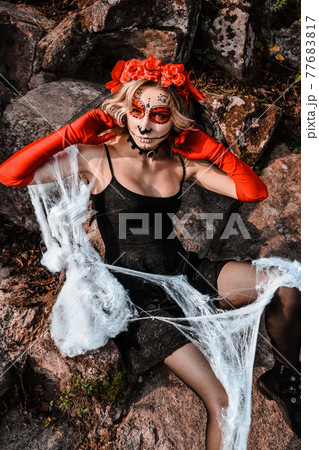 Closeup portrait of Calavera Catrina. Young woman with sugar skull makeup and white spiderweb. Dia de los muertos. Day of The Dead. Halloween. 77683817
