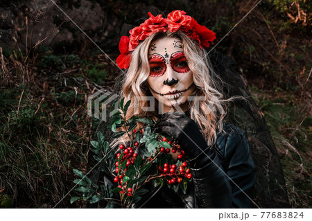 Closeup portrait of Calavera Catrina. Young woman with sugar skull makeup and red flowers. Dia de los muertos. Day of The Dead. Halloween. Closeup portrait of Calavera Catrina. Young woman with sugar skull makeup and red flowers. Dia de los muertos. Day of The Dead. Halloween. 77683824