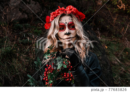 Closeup portrait of Calavera Catrina. Young woman with sugar skull makeup and red flowers. Dia de los muertos. Day of The Dead. Halloween. Closeup portrait of Calavera Catrina. Young woman with sugar skull makeup and red flowers. Dia de los muertos. Day of The Dead. Halloween. 77683826