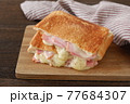 木のテーブルととろ～りとろけるハムチーズのホットサンド 77684307