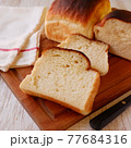 焼き立て食パンのスライスと白いテーブルとクロス 77684316