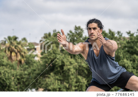 Athlete man doing gymnastic exercises to strength muscles 77686145
