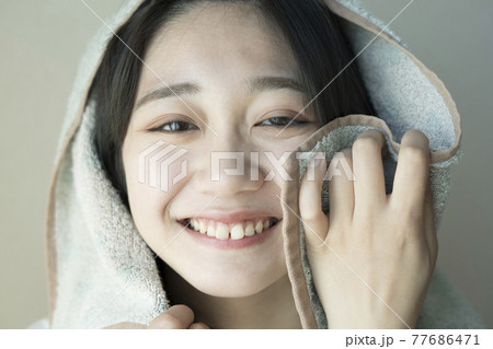 タオルで顔を拭く女性 タオルで顔を拭く女性 77686471