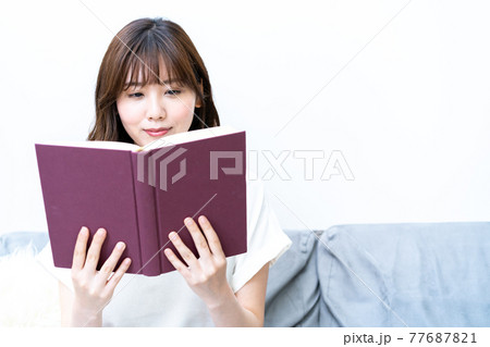 ソファで読書をする若い女性 ソファで読書をする若い女性 77687821