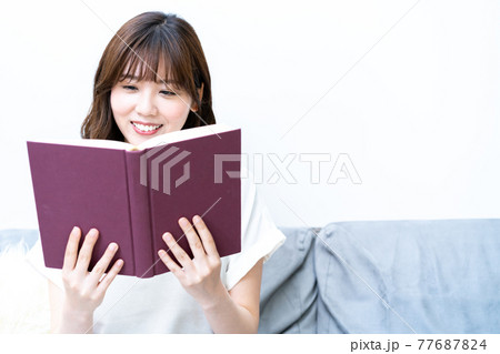 ソファで読書をする若い女性 ソファで読書をする若い女性 77687824