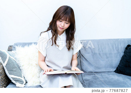ソファで読書をする若い女性 ソファで読書をする若い女性 77687827