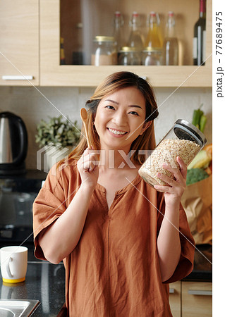 Woman with jar of oatmeal 77689475