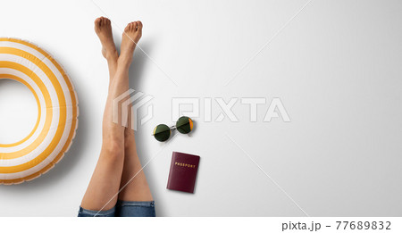 Flat lay top view of legs of woman with travel essentials, summer holiday concept. 77689832