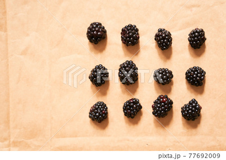 Twelve blackberries on a beige craft paper background, form of a rectangle 77692009