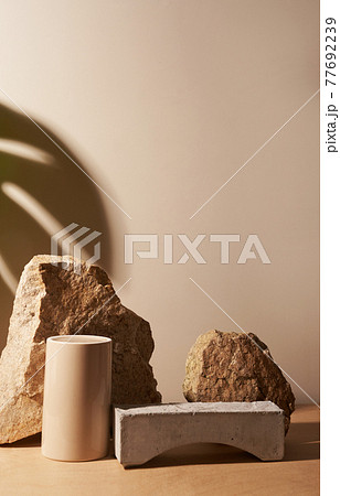 Stone and a piece of tile podium on a beige background 77692239