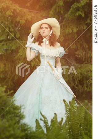 A beautiful young woman in a historical blue dress 1860 year. Book cover design. 77692356