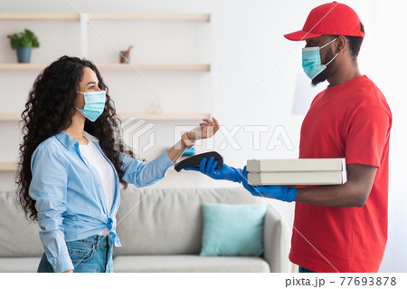 Black delivery man holding pizza box and pos terminal 77693878