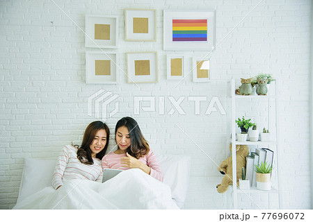 Lesbian couple homosexual happiness lifestyle on bed. Two pretty girlfriend talk, hug and laugh together relation fall in love. LGBTQ relation lifestyle concept. 77696072