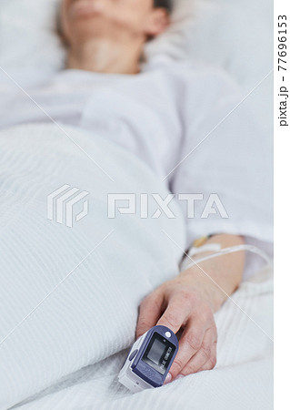 Female patient lying on bed 77696153