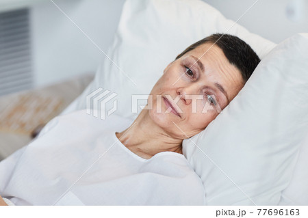 Woman lying in bed Woman lying in bed 77696163