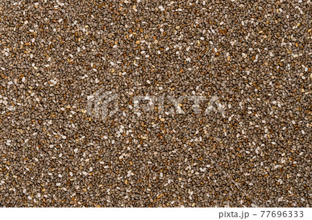 Chia seeds, background, from above. Fruits of Salvia hispanica. Oval and gray fruits with black and white spots, very hygroscopic, giving foods a distinctive gel structure. Backdrop. Macro food photo. Chia seeds, background, from above. Fruits of Salvia hispanica. Oval and gray fruits with black and white spots, very hygroscopic, giving foods a distinctive gel structure. Backdrop. Macro food photo. 77696333