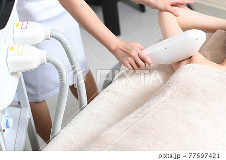 脇の脱毛の施術を受ける若い女性 77697421