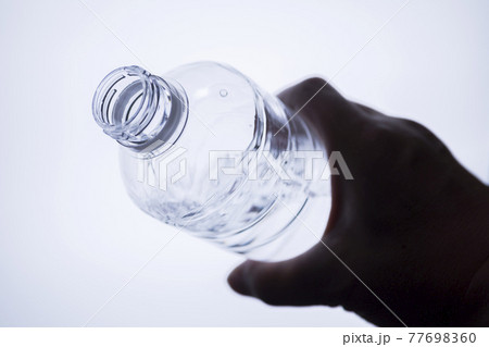 ペットボトルの水を飲もうとしている 77698360
