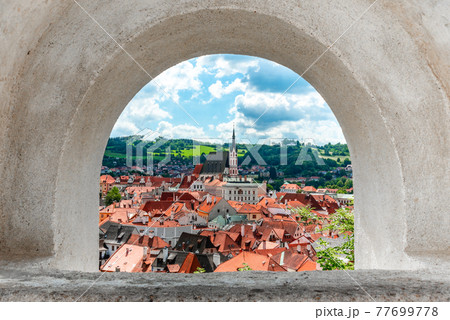 Cesky Krumlov - arch framed view of historical city centre with St Vitus church in the middle. Cesky Krumlov, Southern Bohemia, Czech Republic 77699778